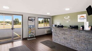 A reception area with a stone wall, a computer desk, and a window.