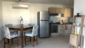 Eine moderne Küche mit einem Edelstahl-Kühlschrank, einem Gasherd und Holzschränken.