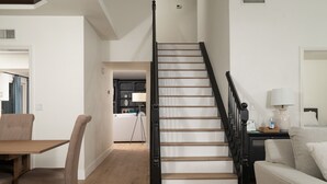 Una escalera con barandilla negra que lleva al segundo piso.