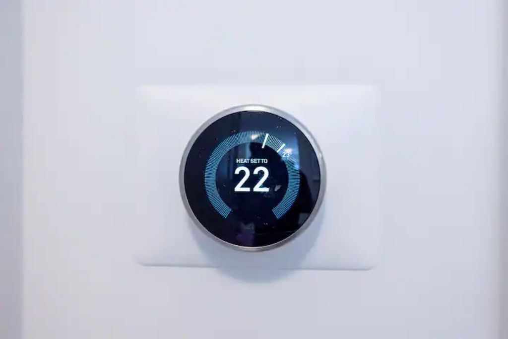 A thermostat with a digital display set to 22 degrees.