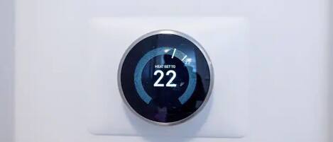 A thermostat with a digital display set to 22 degrees.