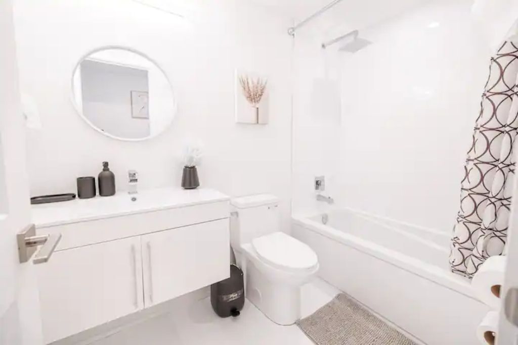 Een moderne badkamer met toilet, wastafel en bad.