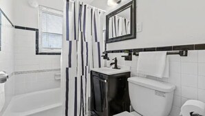 Un bagno moderno con vasca, servizi igienici e lavabo.