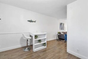 Relax in a serene space with a wall-mounted shelf, bar-style stool, and a cozy seating area.