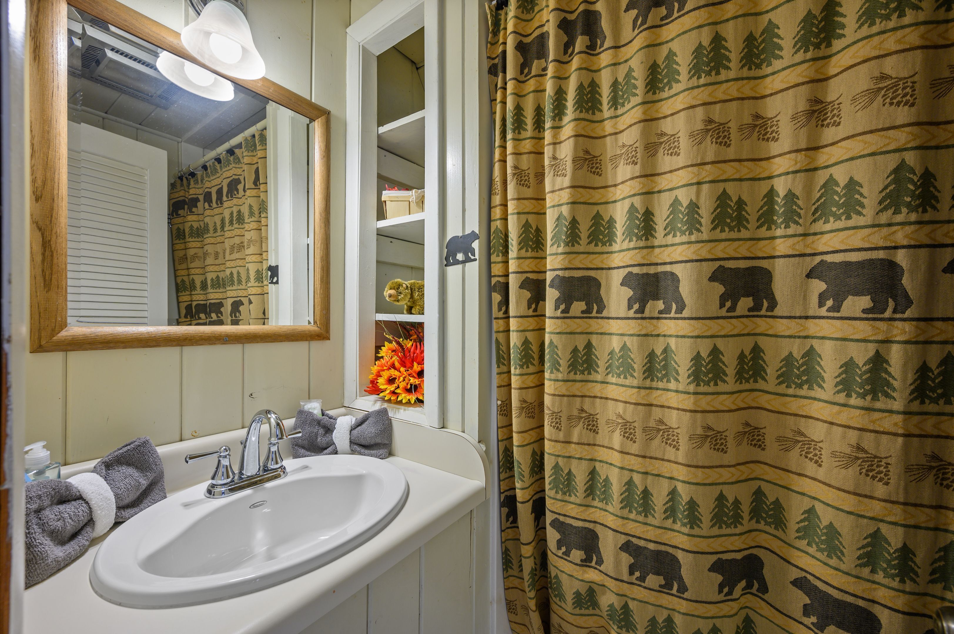 A bathroom with a white sink, mirror, and towel rack.