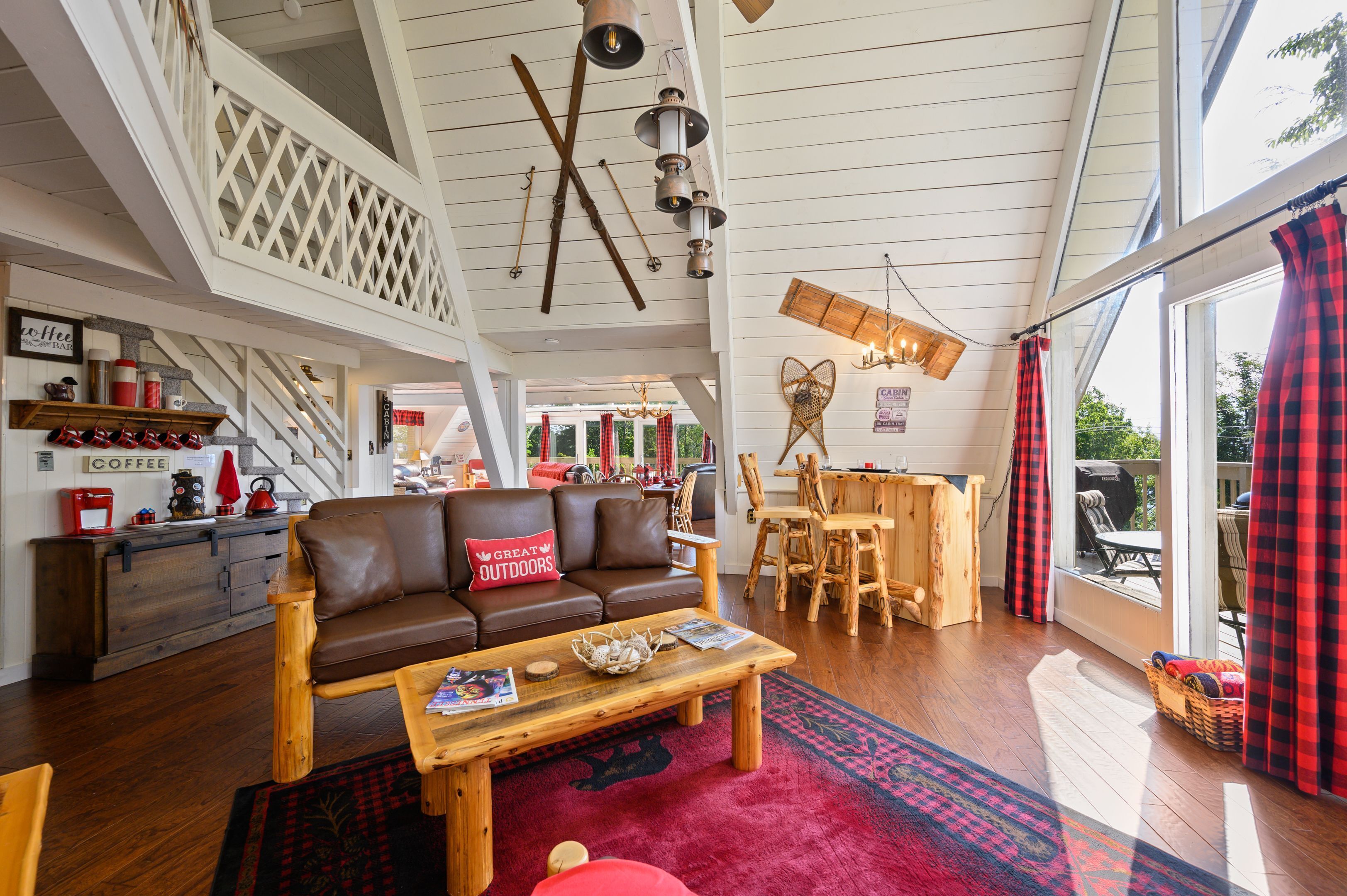 Een ruime woonkamer met een hoge plafond, houten meubels en een gezellige open haard.