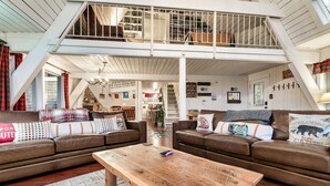 A spacious loft-style living area with high ceilings, exposed beams, and a mezzanine level. - Mtn VIEWS, 4 bedrooms, hot tub, Arcade games, close to Ober + Gatlinburg (Gatlinburg)