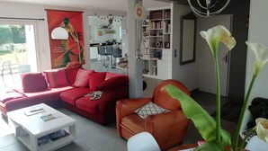 Ett vardagsrum med en röd soffa, ett vitt soffbord och en bokhylla.