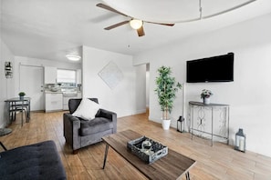 Relax in this spacious living area with a flat-screen TV, dining table, and comfortable sofa.