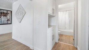 Een moderne badkamer met een douche, toilet en opbergkasten.