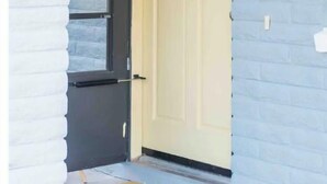 A white door with a black frame and a yellow doorbell. - <Redrock Views><Near Sedona><Hot Tub> (Cottonwood)