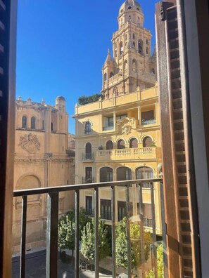 A multi-story building with balconies, arched windows, and a dome structure.
