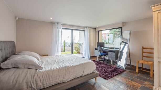 A bedroom with a bed, a desk, and a chair. There is a window with curtains and a view of the outside. - Bed & breakfast on a hillside with direct access to Colmar (Niedermorschwihr)