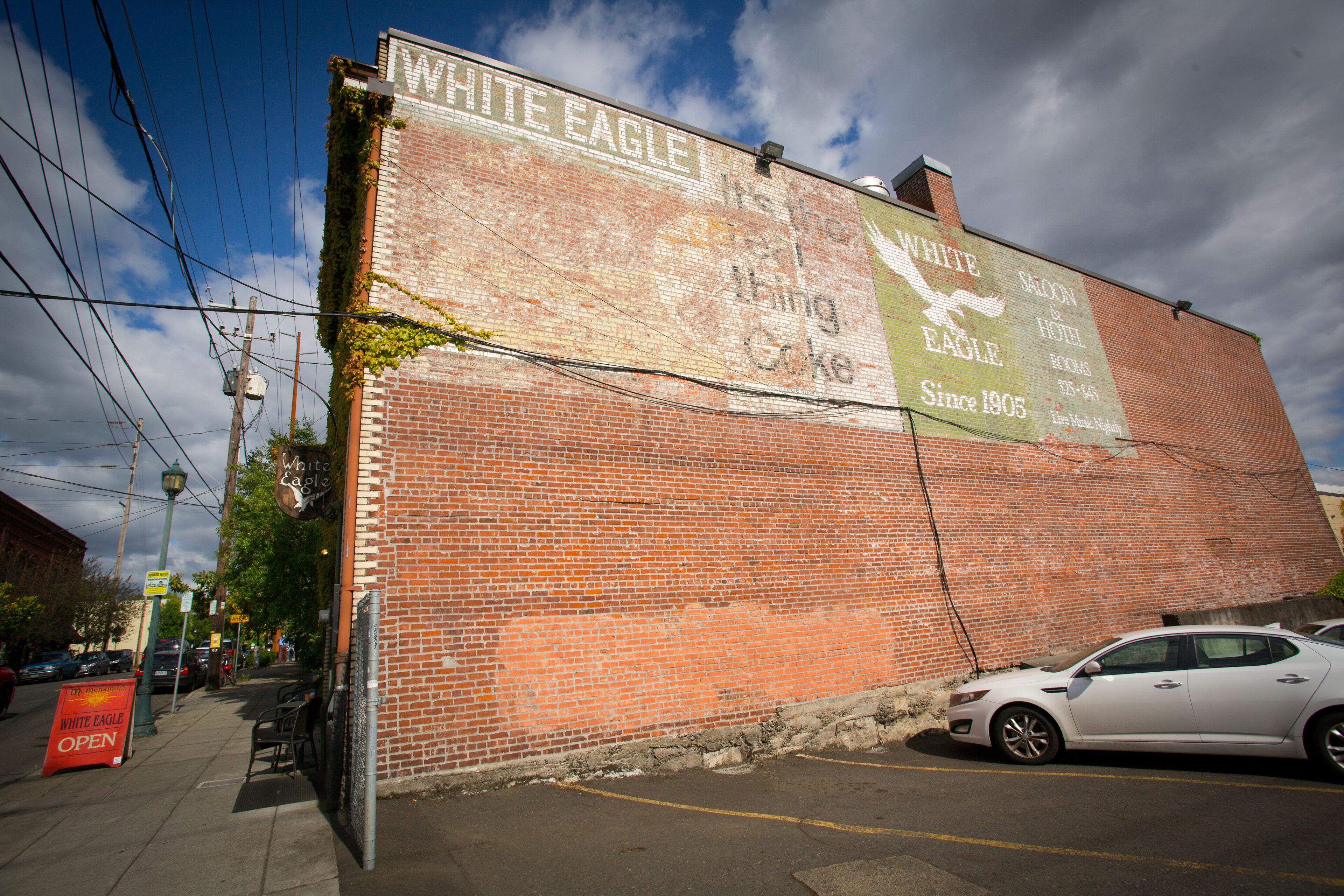 Ein Backsteinhaus mit einem großen Schild, das das White Eagle Saloon & Hotel bewirbt.