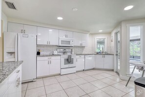 A modern kitchen with white cabinetry, a microwave, oven, and a dishwasher. - Siesta Key FL: Heated Pool, Beaches, Family Fun (Sarasota)