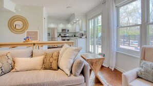 A modern kitchen with white cabinets, a microwave, and a dining area with a wooden table and chairs. - The Retreat - Private Pool-Spa-Firepit-Gameroom (Greenwood)