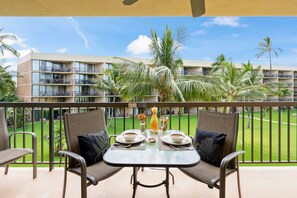 Enjoy a serene view of the well-manicured lawn from this balcony, perfect for a romantic evening with a refreshing drink.