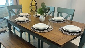 Una mesa de comedor servida con platos, vasos y un centro de mesa.