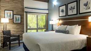 A hotel room with a large bed, two bedside lamps, a wooden headboard, and framed artwork on the wall. - Discover Vail's Best Kept Secret. Great family location. Sleeps up to 8. (Vail)
