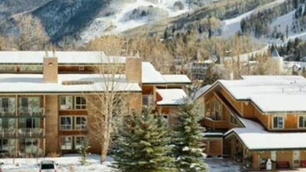 A lodge with a modern design, featuring a large glass facade and a wooden exterior. It is situated in a mountainous area with a view of snow-covered slopes. - Discover Vail's Best Kept Secret. Great family location. Sleeps up to 8. (Vail)