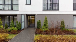 A modern building with a central entrance, glass doors, and a pathway leading to the entrance.