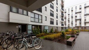 A modern building with a bike parking area and a paved walkway.