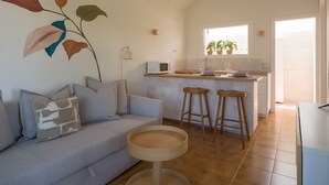 Una cocina moderna con comedor, un sofá y un amplio ventanal.