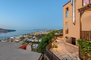 A coastal town with a view of the sea, a paved pathway, and a building with a balcony. - Sunset Villa - Panorama Sea View Villa (Platanias)