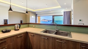 A modern kitchen with a large window, a built-in sink, and a kettle on the counter. - Sunset Villa - Panorama Sea View Villa (Platanias)
