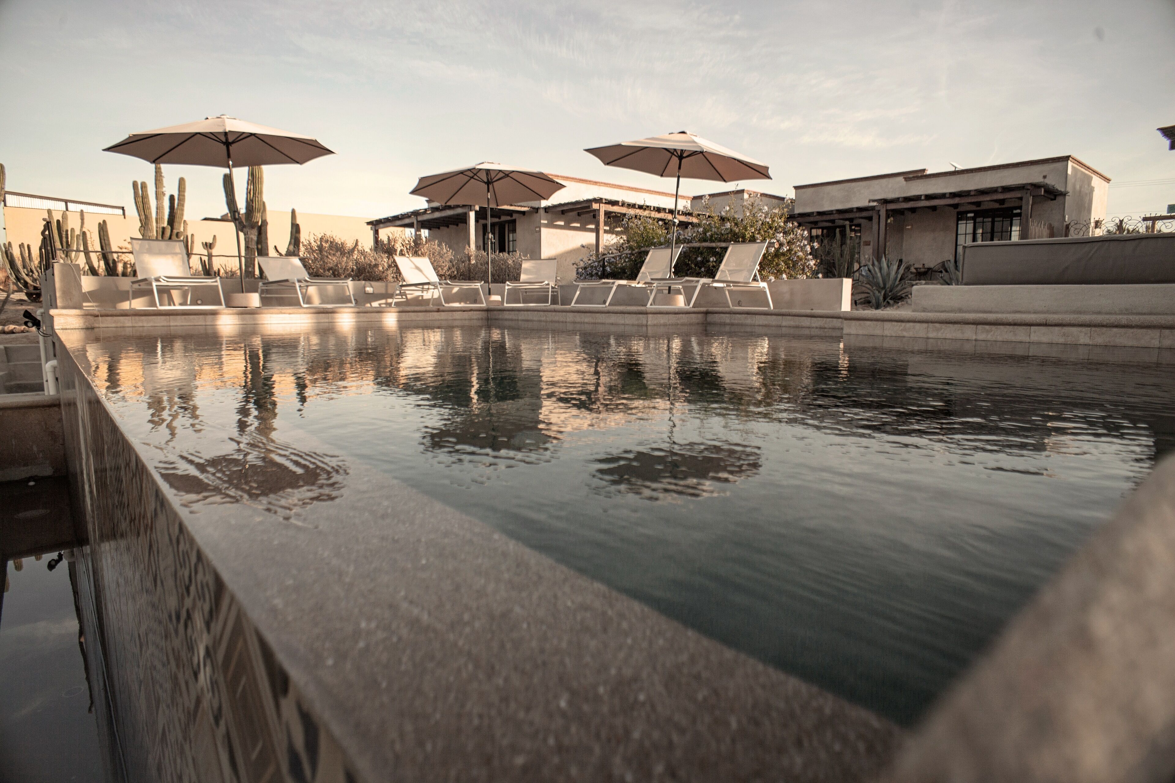 Un espace piscine équipé de chaises longues et de parasols.