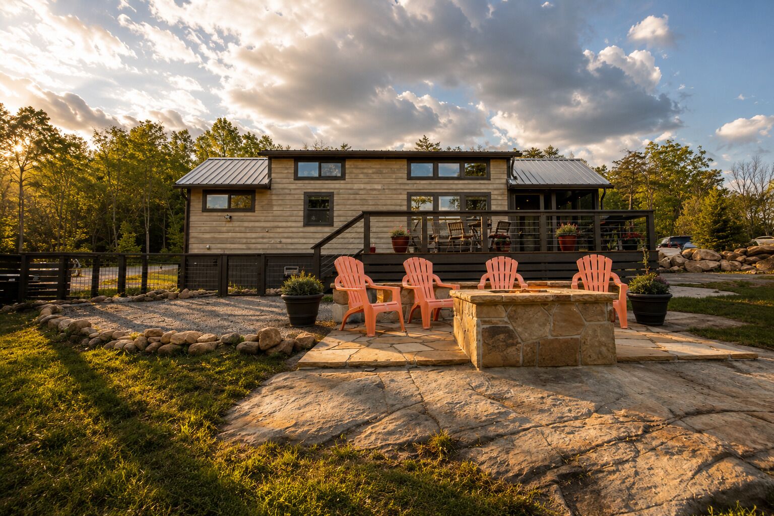 A modern house with a stone patio, outdoor seating, and a view of the surrounding landscape.