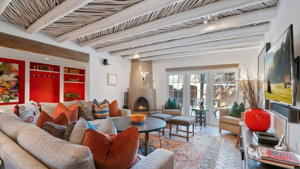 Una sala de estar acogedora con chimenea, asientos cómodos y un ventanal grande.