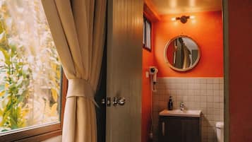 A bathroom with a toilet, sink, and mirror.