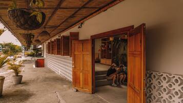 A covered outdoor area with wooden doors and steps leading to a building.