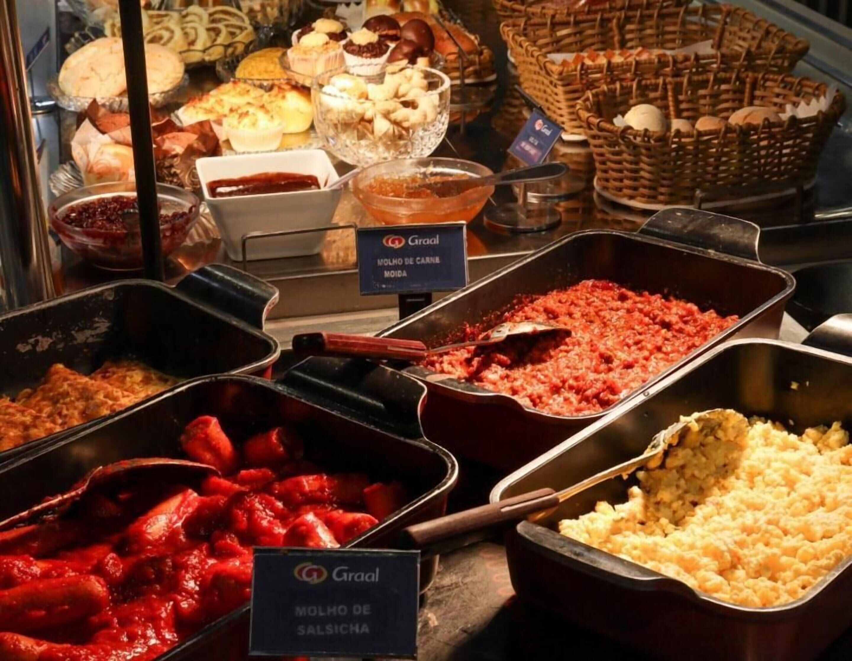 A buffet with various dishes including Molho de Carne Moida and Molho de Salsicchia.