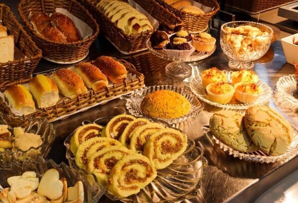 Diversas opciones de panadería y pastelería expuestas en cestas y sobre una mesa.