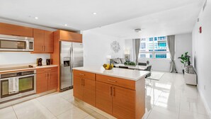 Una cocina moderna con electrodomésticos de acero inoxidable, armarios de madera y una isla grande.