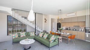 En moderne stue med en hjørnesofa, spiseplads og et køkken.