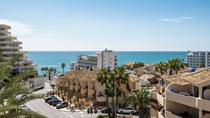 Un hôtel situé sur la côte, avec plusieurs étages, des balcons et une vue sur la mer.