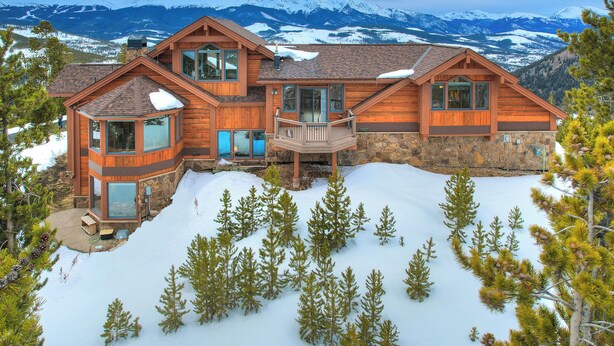 A large wooden house with multiple levels, large windows, and a stone foundation, surrounded by snow and pine trees. - 🏆 Breck Private Estate | Hot Tub | 360° Views | 7 Acres (Breckenridge)
