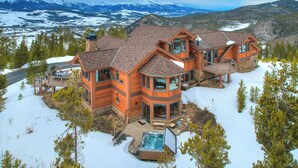 A large log cabin with multiple decks and a hot tub, surrounded by snow and mountains. - 🏆 Breck Private Estate | Hot Tub | 360° Views | 7 Acres (Breckenridge)