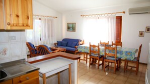 Un espacio habitable compacto con cocina, comedor y zona de estar.