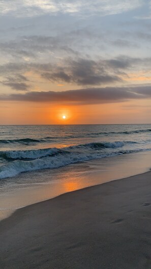 A beach with waves at sunset. - Coastal Luxury home just steps from the beach.   Live an island life.
 (Indian River Shores)