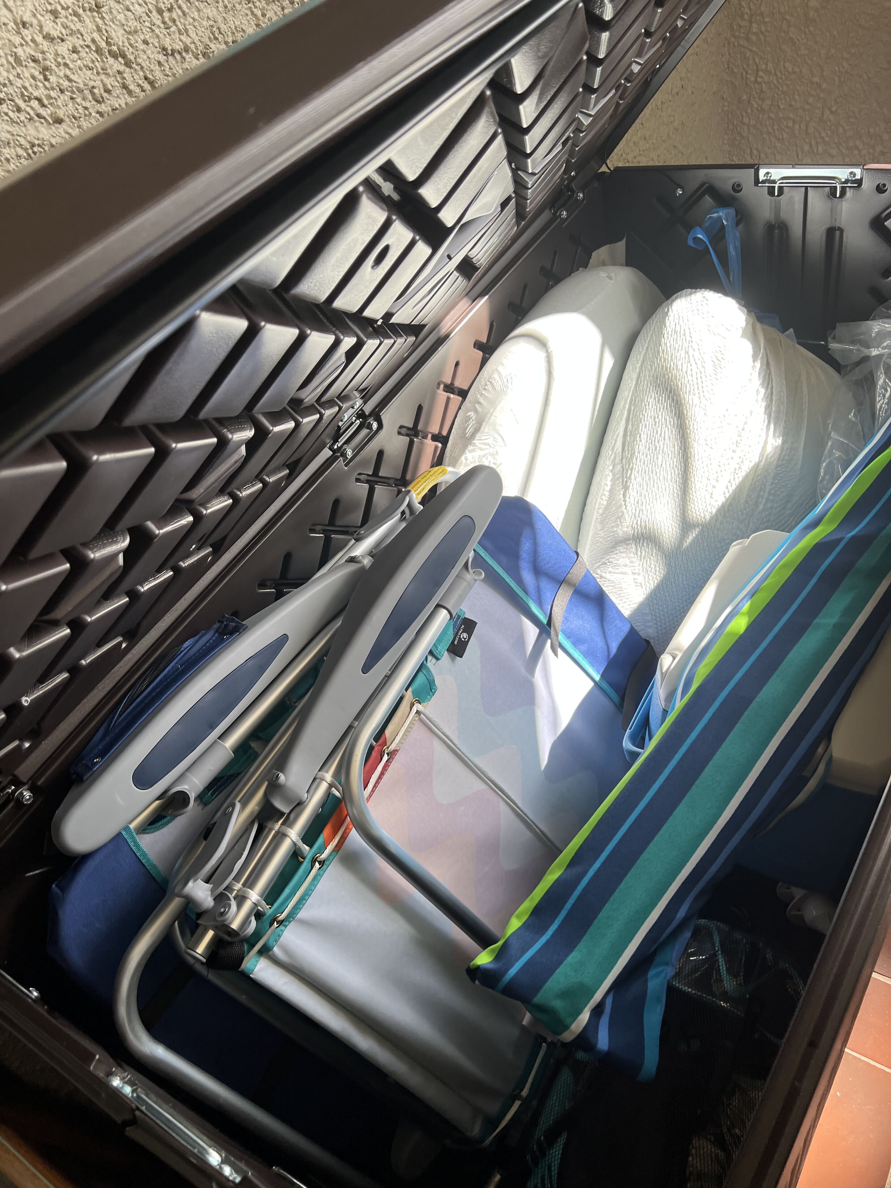 Un coffre de voiture avec un toit noir, un sac à rayures bleues et blanches, et un sac en plastique blanc.