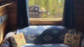 A cozy cabin room with a window view of a forest. - Cozy Quiet Alaskan Cabin (Soldotna)