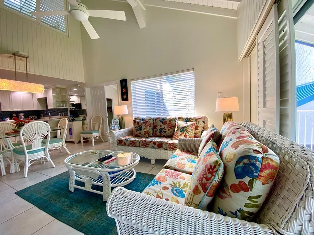 A spacious living area with a sofa set, a coffee table, and a dining table with chairs.