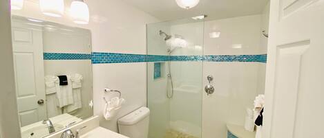 A bathroom with a sink, toilet, and shower.