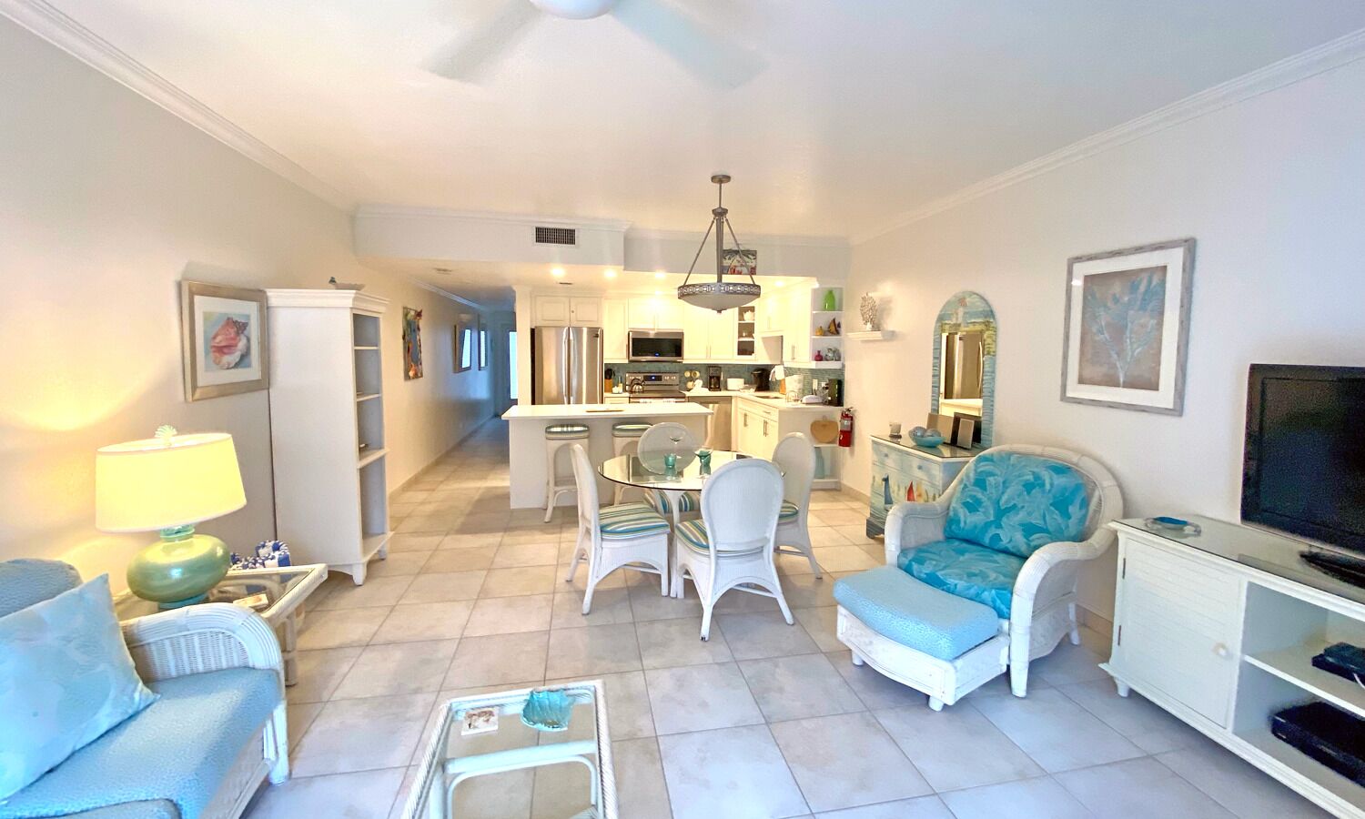 A living room with a dining area, kitchen, and a TV.