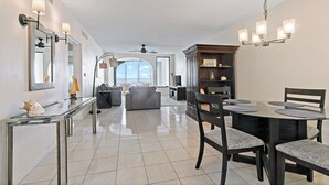 Un amplio salón con una mesa de comedor, sillas y una cocina moderna al fondo.