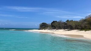A beach with clear turquoise water and a sandy shore. -  St. Croix Escape★ Oceanfront Oasis with Stunning Views and Serene Coastal Vibes (Christiansted)